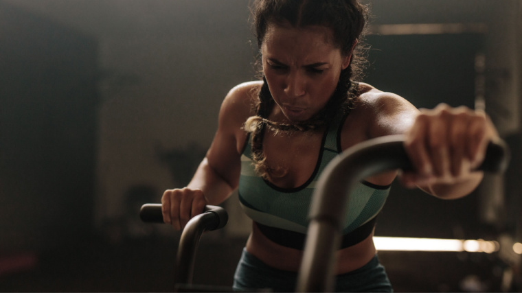 person in gym exercising on air bike