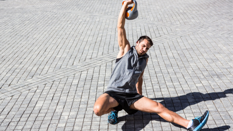 person outdoors lifting kettlebell