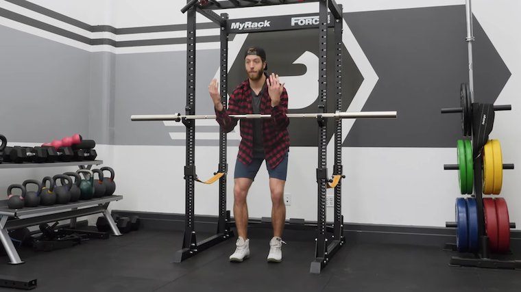 Man holding barbell in elbows