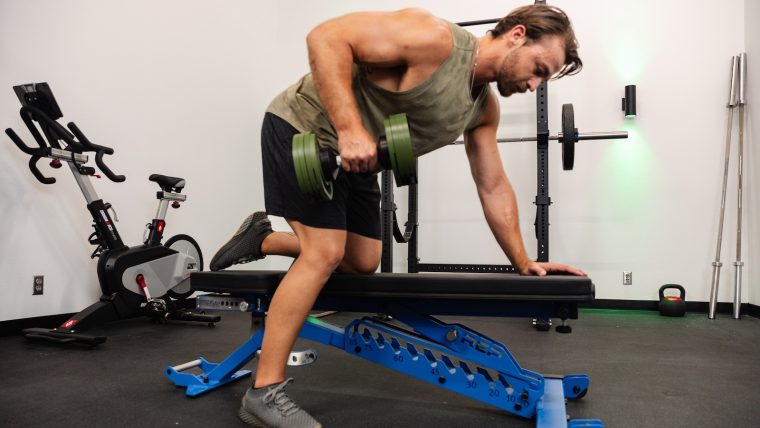 Breaking Muscle team member uses the REP Fitness BlackWing Adjustable Bench to perform a row.