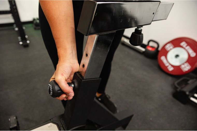 An athlete adjusting the seat height on the Rogue Echo Bike