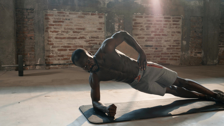 Muscular man performing ab exercise on groung