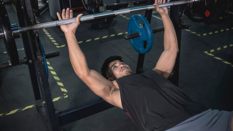 Man grabbing bar to perform bench press