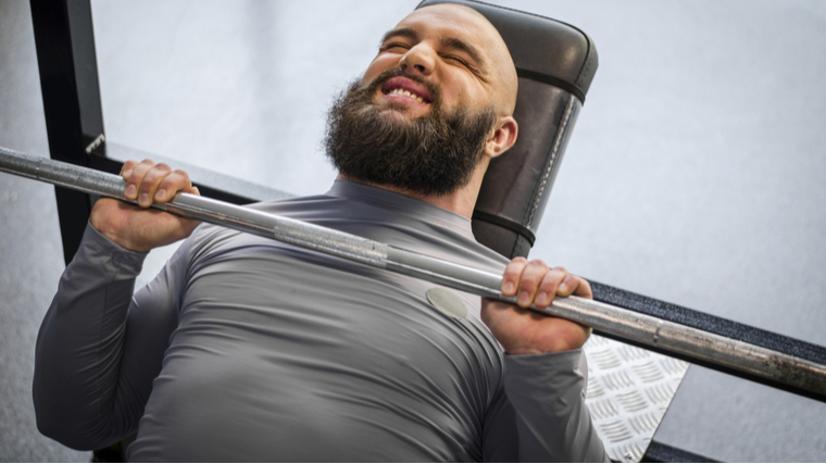 Man stuck under barbell during bench press