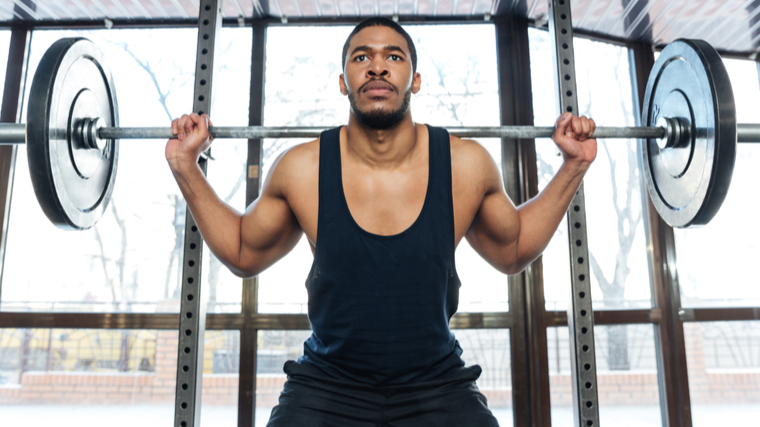 person in gym preparing to barbell squat