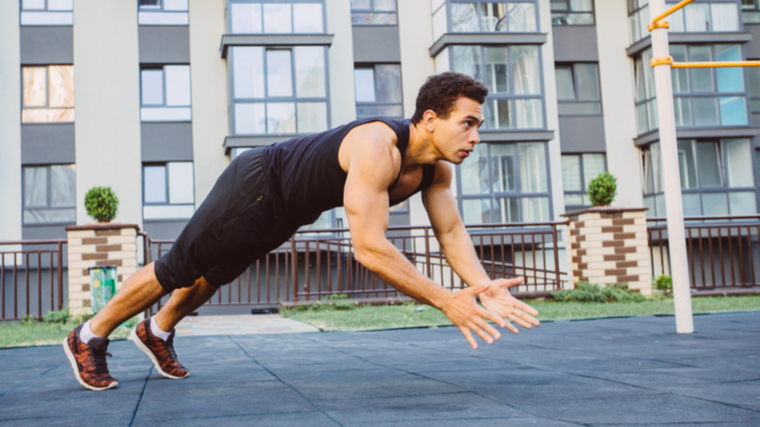 man outdoors performing explosive push-ups